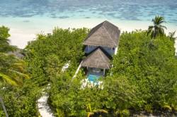 vila na pláži Malediv obklopená zelení